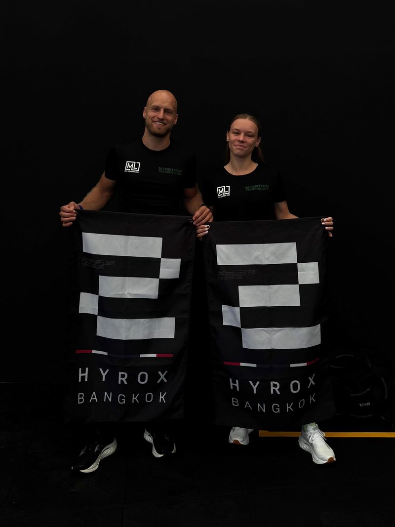 Twee atleten in Momentom Training Club shirt met de Hyrox Bangkok vlaggen