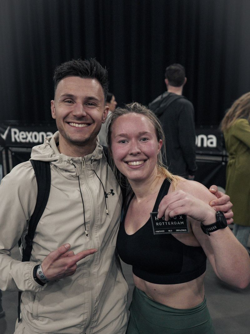 Atlete van Momentom toont haar Hyrox Rotterdam finisher-patch